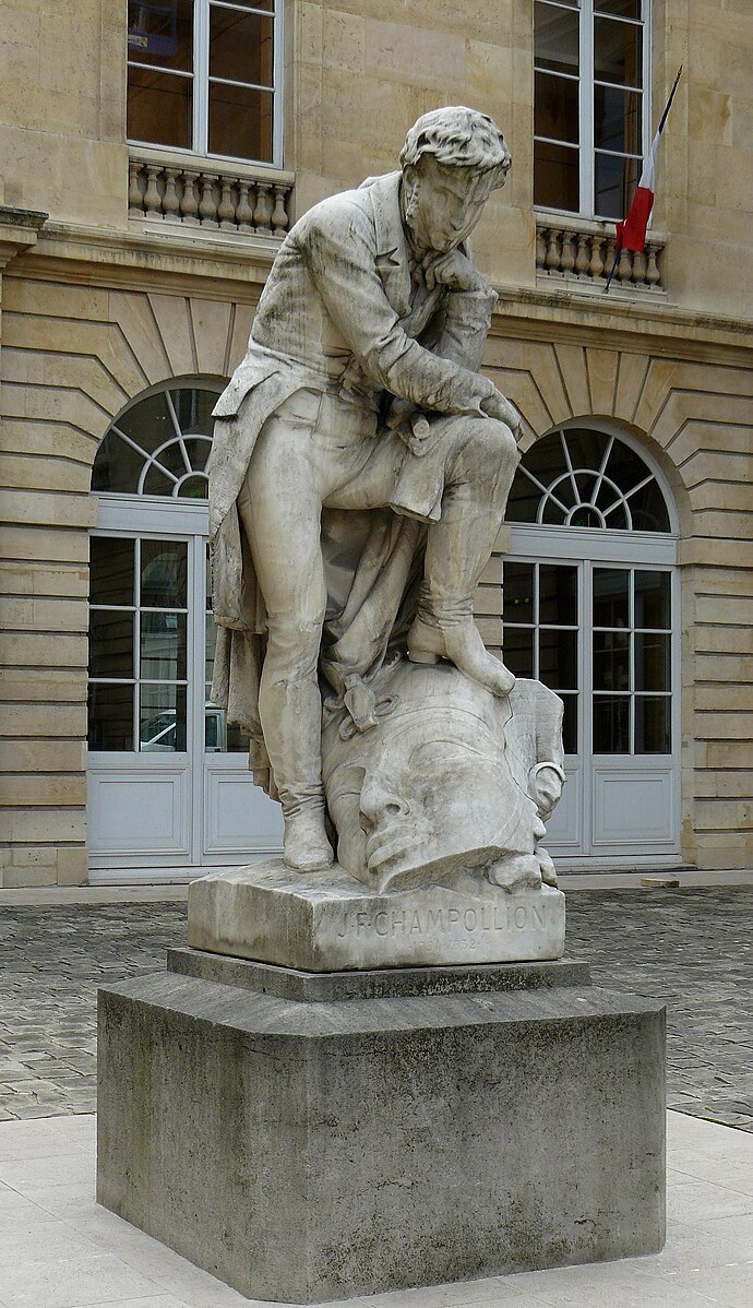  Statue de Jean-François Champollion, par Frédéric-Auguste Bartholdi, (marbre, 1875) - Cour sur rue du Collège de France, rue des Écoles, 5e arr. de Paris.